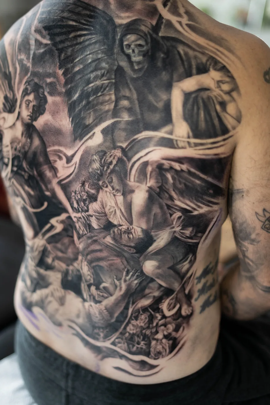 Torse complet, scène mythologique anges et crâne réaliste noir et gris — Nima Tattoo Montréal