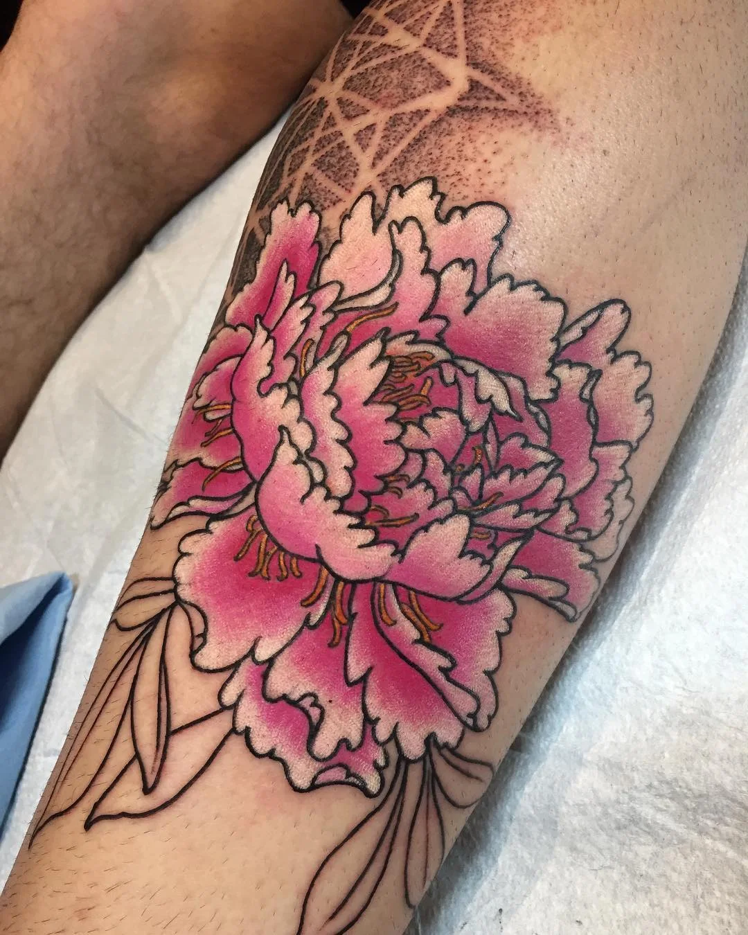 Tatouage de pivoine japonaise rose avec fond pointilliste par Nima Tattoo Montréal