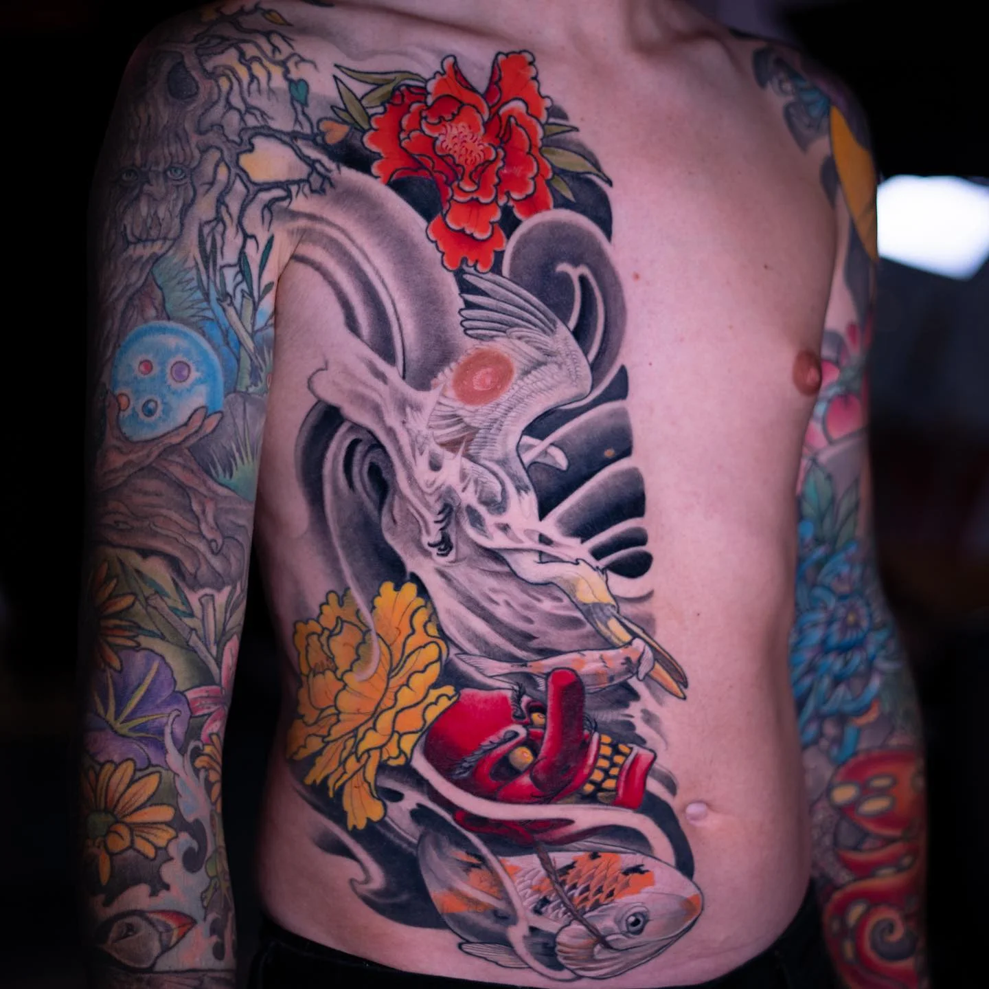 Tatouage de torse néo-japonais avec grue, crâne, koï et pivoines par Nima Tattoo Montréal