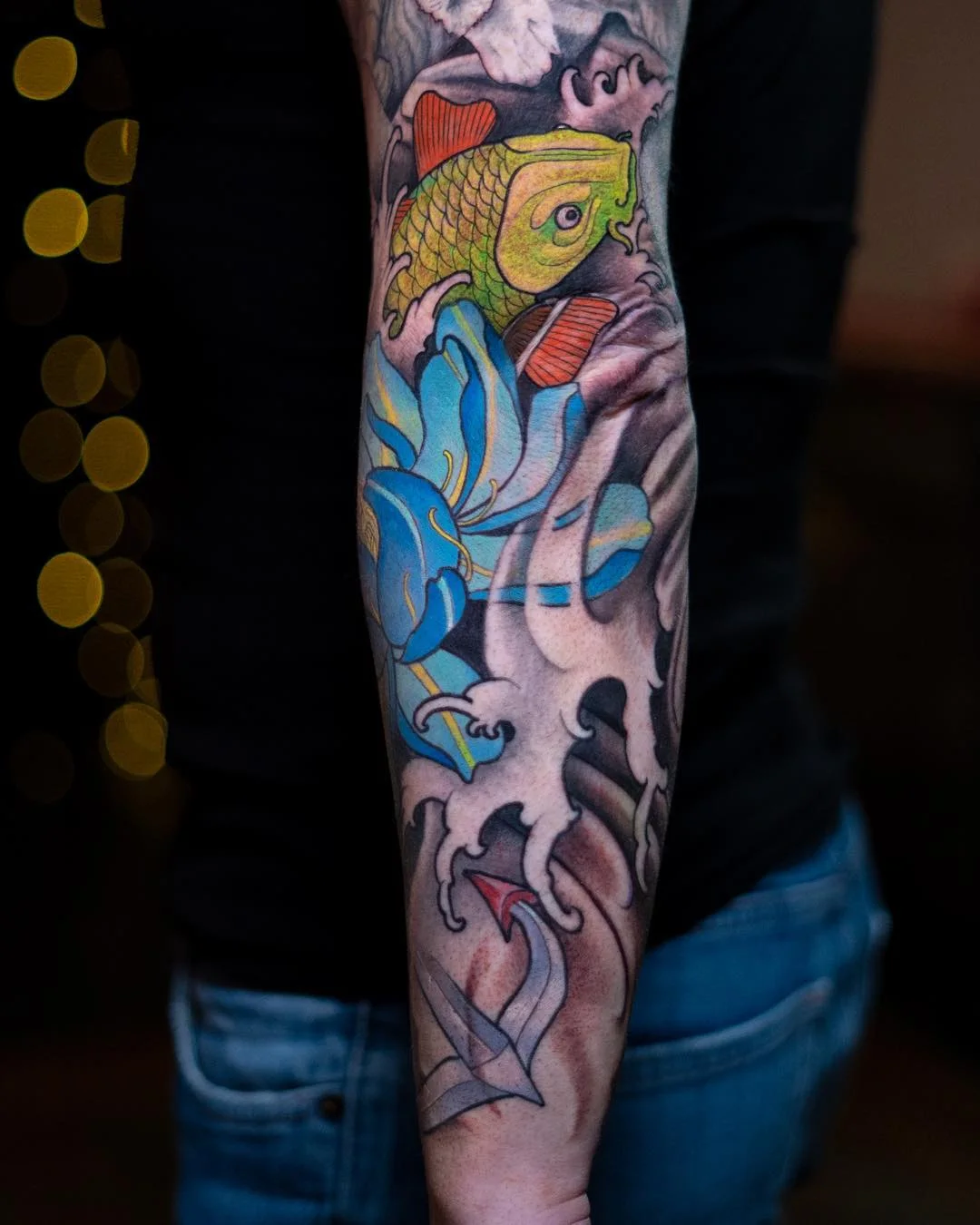 Tatouage d'avant-bras néo-japonais avec carpe koï et fleur bleue par Nima Tattoo Montréal