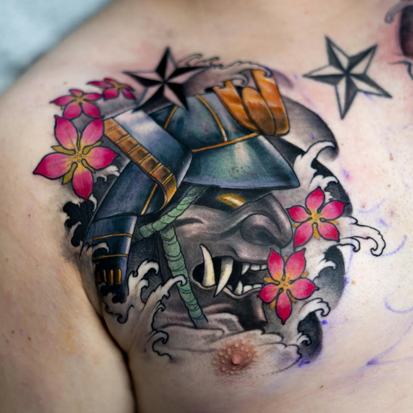 Tatouage de torse avec masque de samouraï, vagues et fleurs de cerisier par Nima Tattoo Montréal